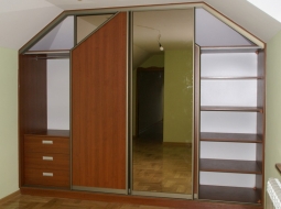 Szafa wnękowa na poddaszu wykonana w systemie RAUMPLUS (drzwi przesuwne). Wypełnienie drzwi z płyty meblowej oraz luster. Tego rodzaju zabudowa dzięki różnorodnym formom adaptacji wnętrza pozwala na optymalne wykorzystanie miejsca na poddaszu.
