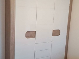 Szafa. Rama z płyty laminowanej w kolorze drewna. Fronty MDF lakierowany na połysk. Uchwyty frezowane.